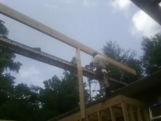 Carpenter setting a ridge beam over a new addition frame — Ice Dam Removal by Roofing Brothers in Pleasantville